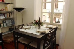 mesa de comedor con sillas y mesa con ventana en La Casa di Ringhiera - silenzioso appartamento di charme con balcone nel quadrilatero romano, en Turín