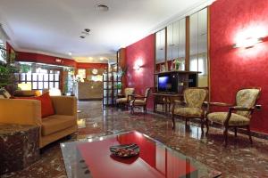 a living room with a couch and chairs and a tv at Hotel Los Angeles in Figueres