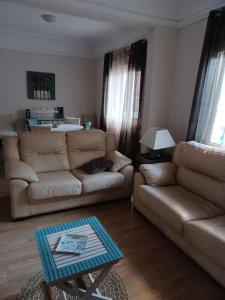 a living room with a couch and a table at El Marques 28 by emepas in Logroño