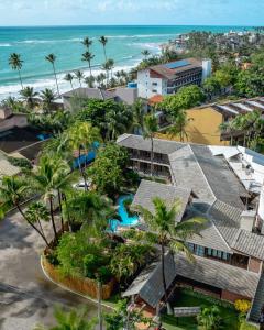 an aerial view of a resort with palm trees and the ocean at Pousada Pérola do Porto in Porto De Galinhas