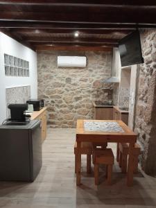uma cozinha com uma mesa de madeira num quarto em Cantinho D'Avó Maria em Zebreira
