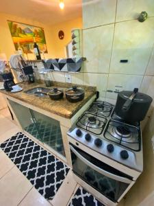 a kitchen with a stove and a sink at Camping Green house in Saquarema +35 photos