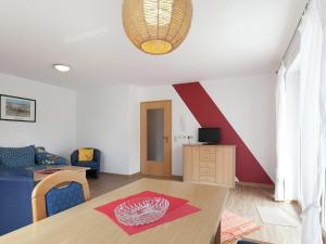 a living room with a table and a red stripe on the wall at Spacious Apartment near Forest in Bad D rrheim in Bad Dürrheim