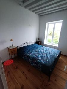 sypialnia z łóżkiem z niebieską kołdrą i oknem w obiekcie Chantilly Villa Quincampoix w mieście Chantilly +6 zdjęć