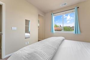 Schlafzimmer mit einem Bett und einem Fenster in der Unterkunft MidTown Luxe Stay—King Beds, Ensuite Baths, Great Location in Reno