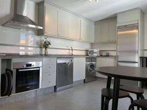 kuchnia z białymi szafkami i stołem w obiekcie Penthouse with sea views in Marbella w Marbelli