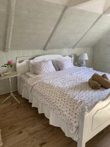 a bedroom with a white bed with a white comforter at Hoby Kulle Herrgård B&B in Bräkne-Hoby