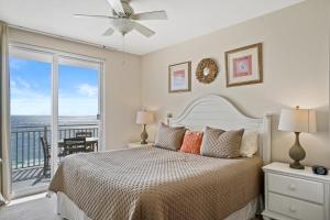 una camera da letto con un letto e un balcone di 607-E-Splash a Panama City Beach Altre 42 foto
