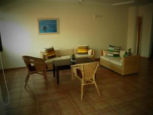 sala de estar con sofá, mesa y sillas en Hostal Albacar en Melenara