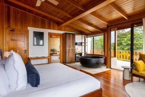 a bedroom with a large bed and a bath tub at Hotel Belmar, a Member of Design Hotels in Monteverde Costa Rica