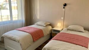 two beds sitting next to each other in a bedroom at Les Passe-Pierres in Merlimont