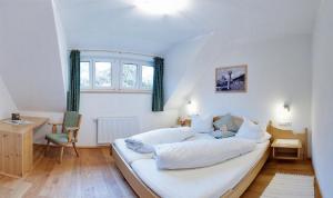 a bedroom with a large white bed with a window at S Mauthäusl Luftenstein in Sankt Martin bei Lofer