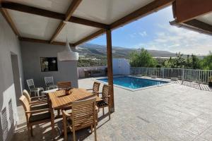 a patio with a table and chairs and a pool at Villa Piedra Pura in Tejina de Isora