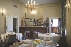 a dining room with tables and chairs and a chandelier at Castello Montegiove in Fano