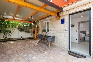 Un patio con una mesa y sillas al lado de un edificio. en Apartment Bonne Vie, en Vižinada
