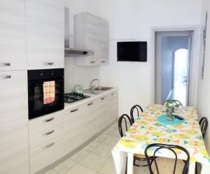 a kitchen with a table with chairs and a stove at Villetta vista mare Donna Lisa in Capilungo +16 photos