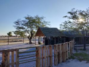a wooden fence in front of a small building at Okuti Kwa Dala Self-Catering Accommodation in Okatana