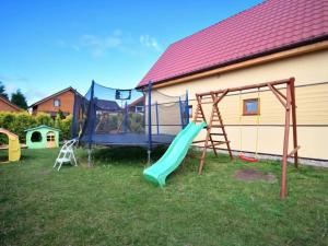 a playground with a slide and a swing at Cottage in Sarbinowo near Baltic Sea Beach in Sarbinowo