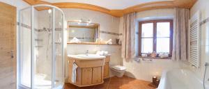 uma casa de banho com um lavatório, um chuveiro e um WC. em S Mauthäusl Luftenstein em Sankt Martin bei Lofer