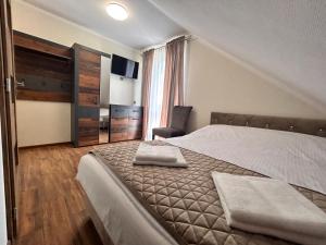 una camera da letto con un letto con due asciugamani sopra di BIAŁY DOM - Pokoje do wynajęcia a Rozogi