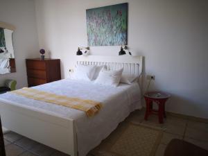 a bedroom with a white bed with a painting on the wall at Apartamento en Playa de Morro jable 1 habitación in Morro del Jable