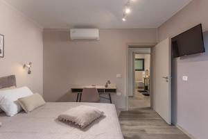 Un dormitorio blanco con una cama y un escritorio. en House Argeo, en Mošćenička Draga