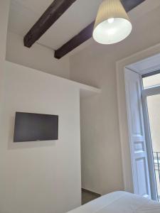 Un dormitorio con una cama y un televisor en la pared. en La Memolina B&B, en Salerno