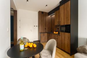 a kitchen with a table with oranges on it at Apartament Shellter Sun&Sea Rogowo koło Kołobrzegu_Dźwirzyno_nocleg in Rogowo +26 photos