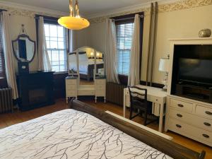 a bedroom with a bed and a desk and a television at Stevenson Farms-Harvest Spa B & B in Alliston