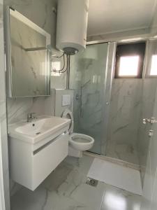 a bathroom with a toilet and a sink and a shower at Nejla Apartmani Stoj in Ulcinj +21 photos