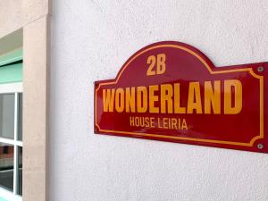 un cartello per una casa delle meraviglie con una lettera su un muro di Wonderland Leiria a Leiria