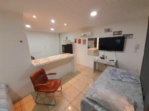 a room with a bedroom with a bed and a tv at JK POUSADA FLAT ECONOMICO com garagem CENTRAL in Pelotas