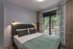 Un dormitorio con una cama y una ventana grande. en House Argeo, en Mošćenička Draga