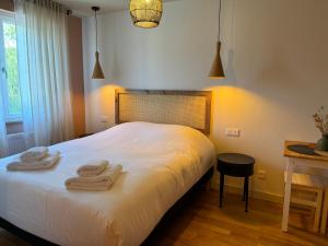 a bedroom with a bed with towels on it at La Maison d'Irmine in Sarralbe