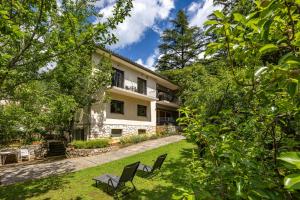 una casa con dos sillas en el patio en House Argeo, en Mošćenička Draga