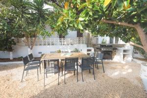 a dining room table and chairs under a tree at Swell S2 maisonette with private Jacuzzi in Naousa in Naousa
