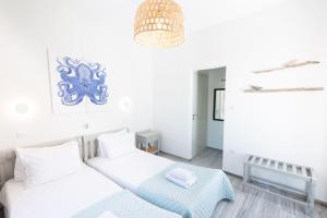 a white room with two beds and a table at Swell S2 maisonette with private Jacuzzi in Naousa in Naousa
