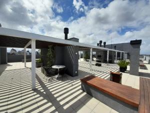 a deck with a bench and a table on a building at JK STUDIO PREMIUM COM GARAGEM SEM taxas extras in Pelotas