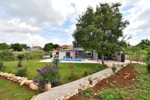 ein Haus mit einem Garten mit Pool in der Unterkunft Villa Vala in Marčana