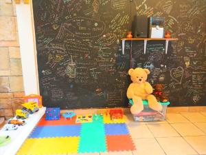a teddy bear sitting on a box in a classroom at Hotel Don Felipe Aeropuerto in Guatemala