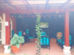 a patio with blue chairs and a table with a plant at Hotel Don Felipe Aeropuerto in Guatemala
