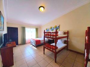 a room with two bunk beds and a bed at Hotel Don Felipe Aeropuerto in Guatemala