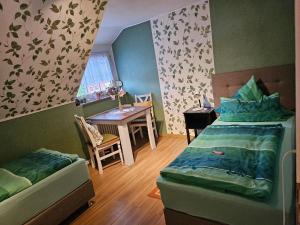 a bedroom with two beds and a table and a tableablish at Ferienwohnung Prinz in Lathen