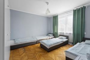 two beds in a room with green curtains at Tanie Spanie Autostrada A2 in Poznań