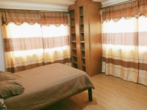 a bedroom with a bed and two windows at Departamento El Rosal 2 in Cuenca