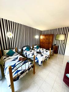 Un grupo de camas en una habitación con paredes rayadas. en Cozy apartment, en San Ġwann