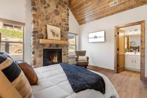 a bedroom with a stone fireplace and a bed at Private Hot Tub-Free Attraction Tickets-Lake Lookout-Community Indoor & Outdoor Pools in Branson