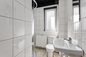 a white bathroom with a toilet and a sink at Tanie Spanie Autostrada A2 in Poznań