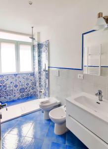 une salle de bain bleue et blanche avec des toilettes et un lavabo dans l'établissement Azure Stay, à Sperlonga