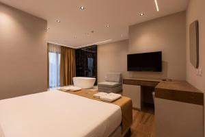 a hotel room with a bed and a desk and a television at Diol Hotel Ksamil in Ksamil